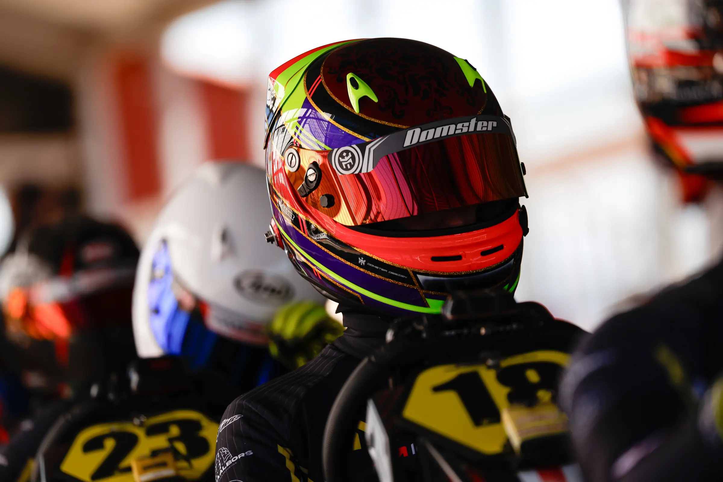 Piloto con casco rojo en boxes